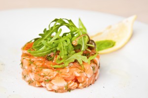 Salmon tartare with arugula, capers and lemon