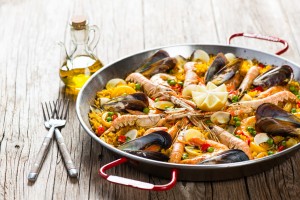 Vegetable paella with seafood on a wooden background
