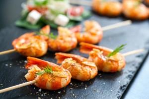 Extreme close up of appetizing grilled queen prawn tail brochettes.